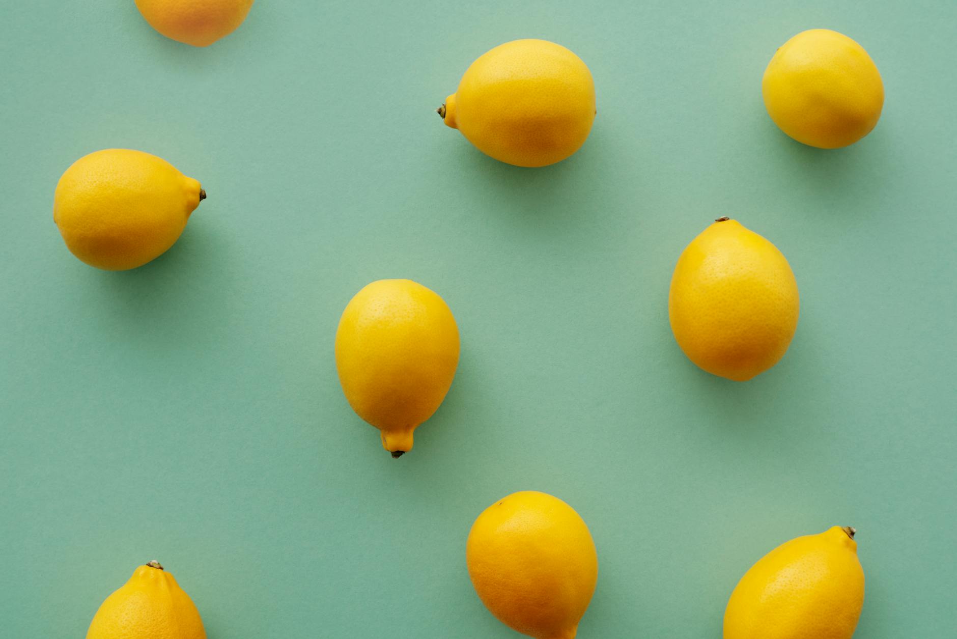 Bright yellow lemons arranged on a pastel background, representing the natural rhythm of the menstrual cycle.