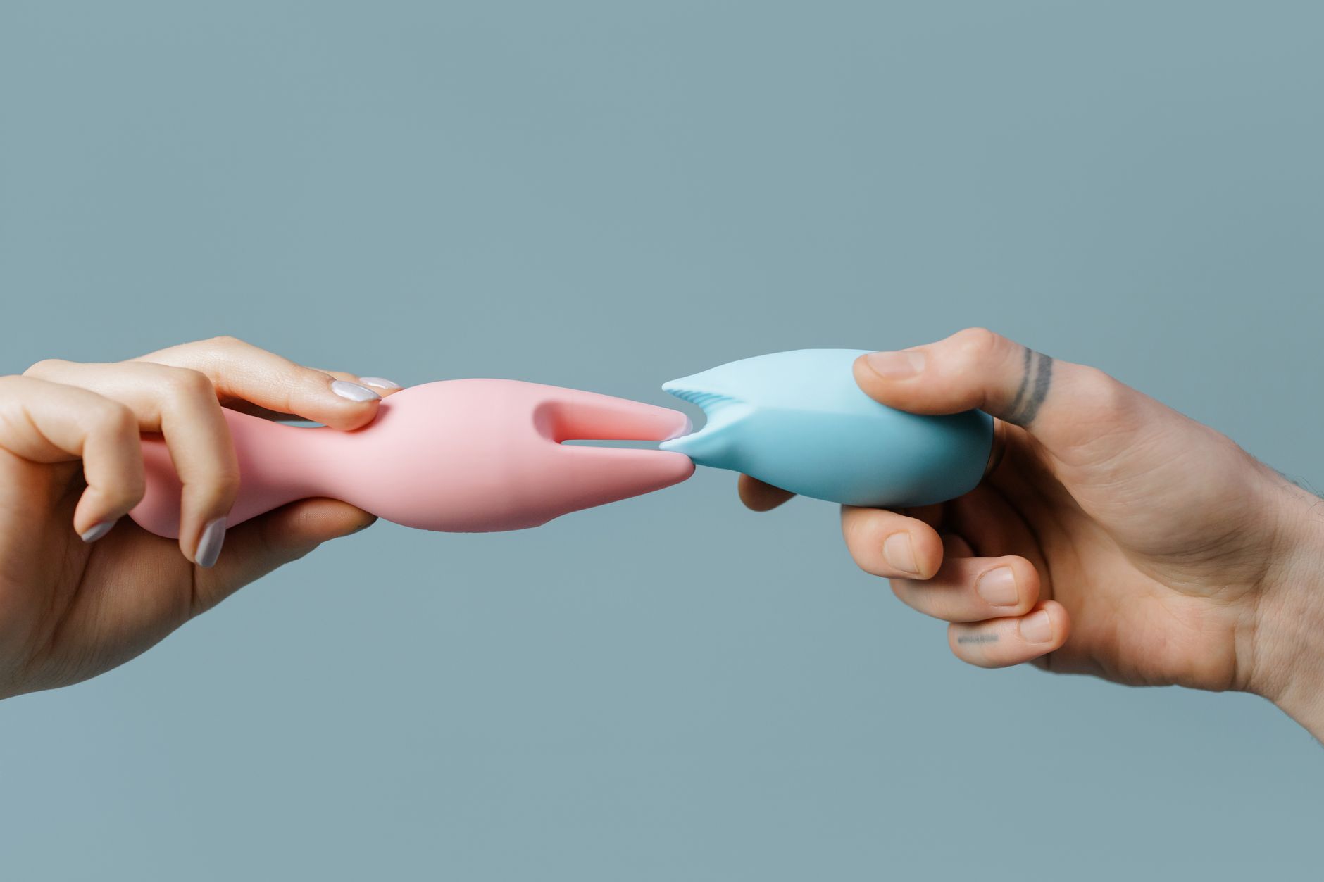Hands holding colorful silicone vibrators during pelvic health recovery