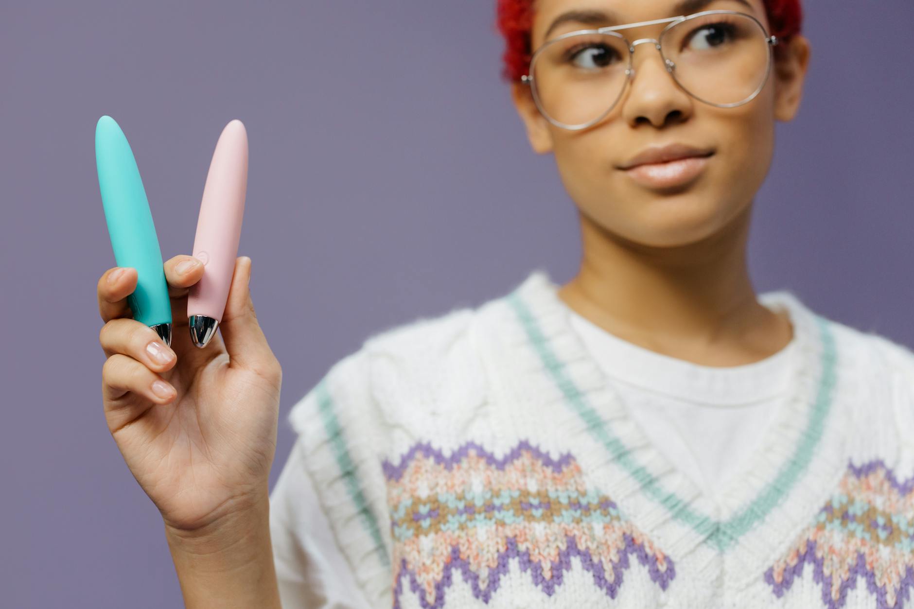 Woman holding colorful vibrators including lemon clitoral options against a purple background